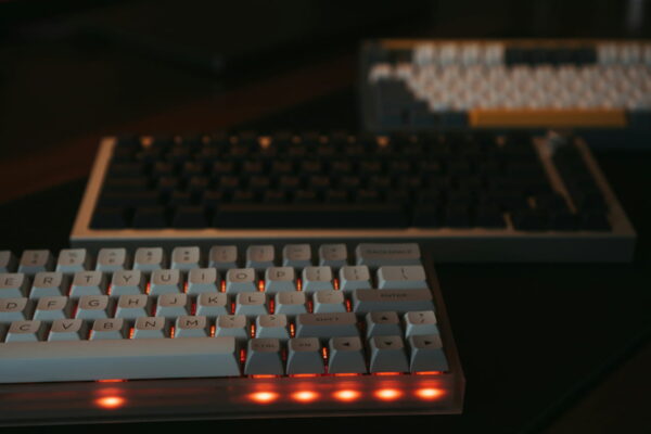 Tastatur kaufen – Mechanische Tastatur mit Beleuchtung im Fokus Mechanische Tastatur mit Hintergrundbeleuchtung, im Vordergrund rot leuchtende Tasten, ideal für Gaming und produktives Arbeiten.